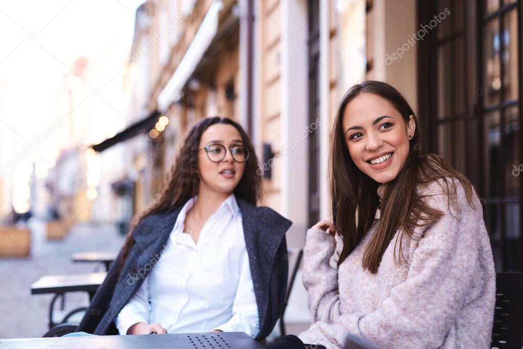two attractive women sitting in the street cafe