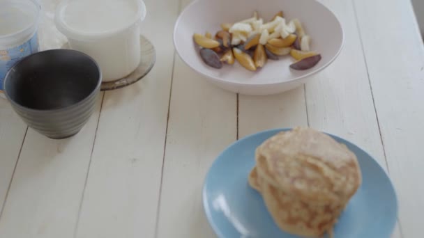 Cámara portátil. platos con panqueques y frutas cortadas para ensalada de frutas para un desayuno saludable . — Vídeos de Stock