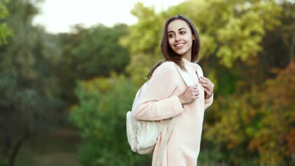 Young pretty Woman hiker with small backpack walking in the autamn forest — Stock Video