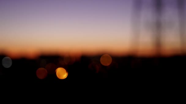 Éjszakai városkép naplemente égbolttal. nem fókuszáló fények éjszakai város — Stock videók
