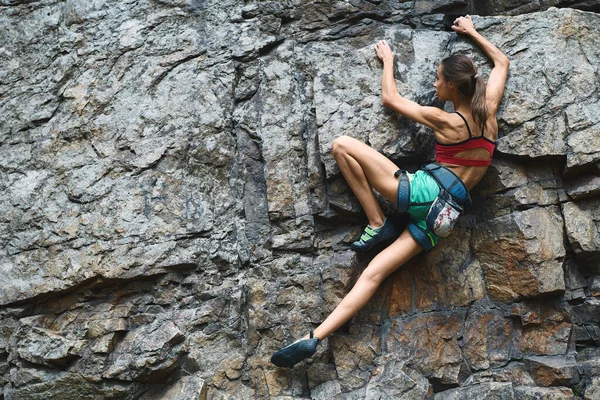 スリムフィットボディのスポーツ女性山の中でワークアウトを持つロッククライミング.岩登りのハードムーブ — ストック写真