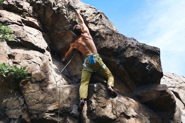 Homem de escalada na rota do esporte difícil, alpinista faz um movimento duro . — Fotografia de Stock