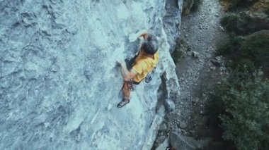 Kaya tırmanışı zorlu bir spor rotasında, kaya tırmanışçısı zor bir hamle yapar ve düşer..