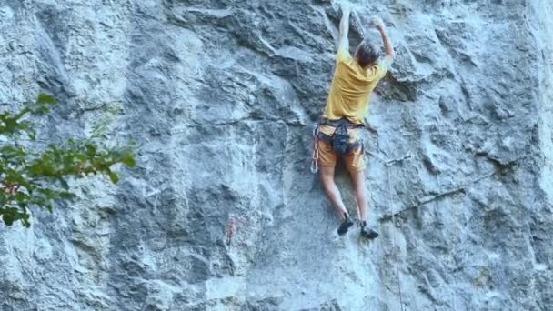 Homme rockclimber accroché à une corde sur la route sportive difficile, mains au repos et craie . — Video