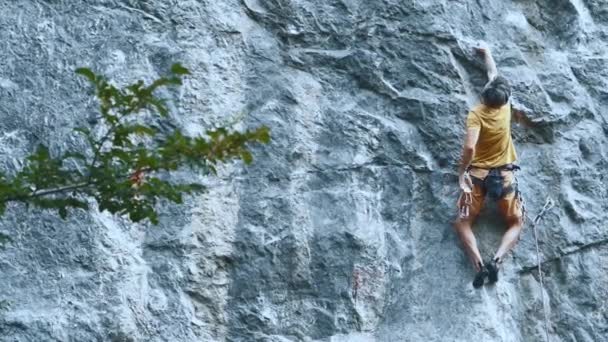 Kaya tırmanışçısı zorlu bir spor güzergahında ipte asılı duruyor, dinleniyor ve tebeşirli eller. — Stok video