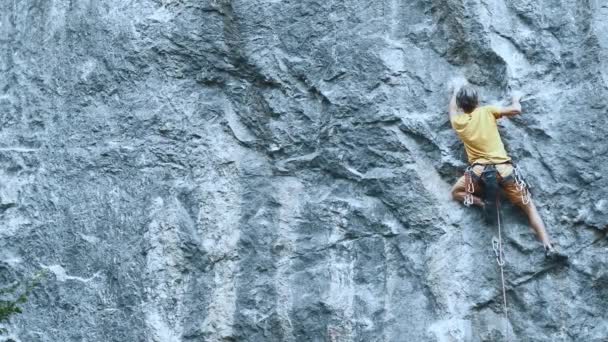 Hombre escalada en roca en la ruta deportiva dura, escalador de roca hace un movimiento duro y cae . — Vídeos de Stock