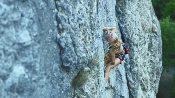 Formda kız kaya tırmanışı zorlu bir spor rotasında, kaya tırmanışçısı zor bir hamle yapıyor ve düşüyor.. — Stok video