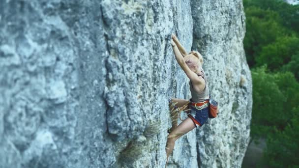 Siyah saçlı sporcu kadın dağlarda spor yaparken kayaya tırmanıyor.. — Stok video