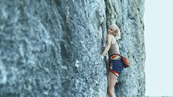 Mulher de esportes com cabelos coloridos Escalando a rocha tendo treino em montanhas . — Vídeo de Stock