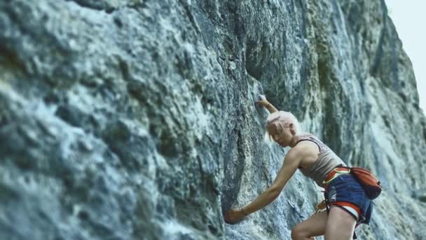 Deportiva mujer con el pelo de color escalada la roca teniendo entrenamiento en las montañas . — Vídeo de stock