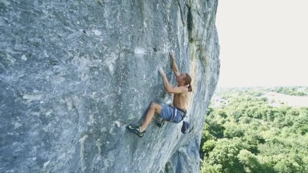 Hombre escalador escalando en un acantilado de piedra caliza — Vídeo de stock