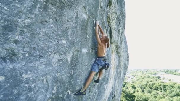 Homem forte muscular escalada na rota do esporte difícil, alpinista faz um movimento duro e cai . — Vídeo de Stock