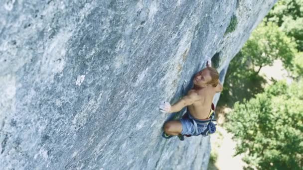 Hombre escalador escalando en un acantilado de piedra caliza — Vídeo de stock