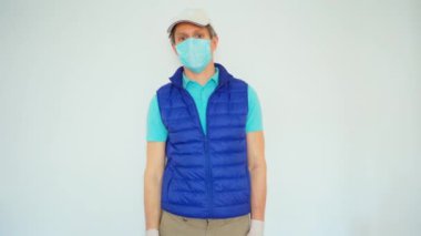 Komik teslimatçı dans ediyor ve beyaz duvarın üzerinden geçiyor.