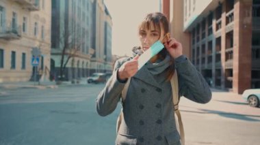 Virüsü korumak için tıbbi maske takan genç bir kadın..