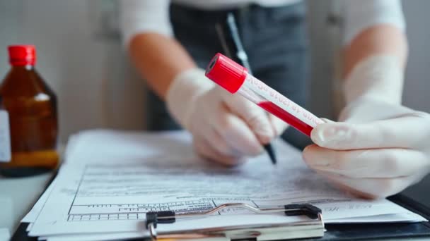 Médico escribe diagnóstico y resultados de la prueba a la historia clínica de los pacientes — Vídeo de stock