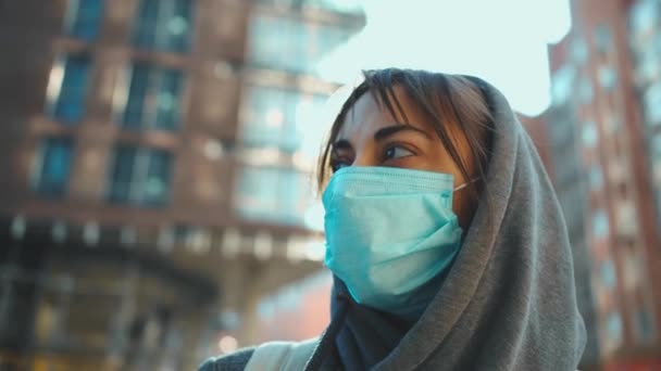 Vrouw in capuchon en medische bescherming gezichtsmasker voor preventie coronavirus — Stockvideo