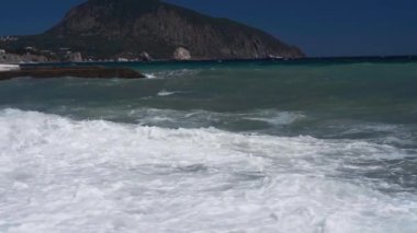 Çakıl taşlı deniz sahilinde ağır çekim dalgaları.