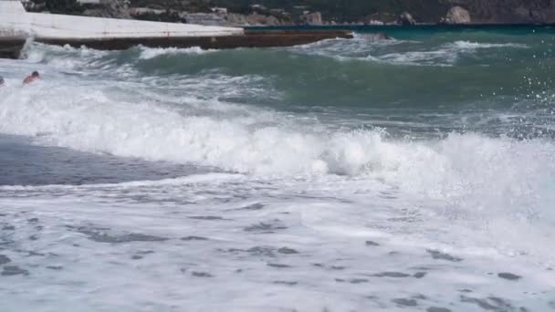 Αργά κύματα κίνησης σε βοτσαλωτή θάλασσα δημόσια παραλία. — Αρχείο Βίντεο