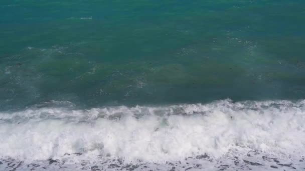 Çakıl taşlı deniz sahilinde ağır çekim dalgaları. — Stok video
