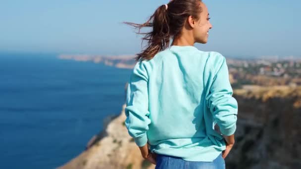 Female traveler stands on background of limewall cliffs and sky — Stock Video