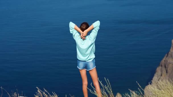 Mujer viajera con los brazos levantados en la cima de la montaña — Vídeo de stock