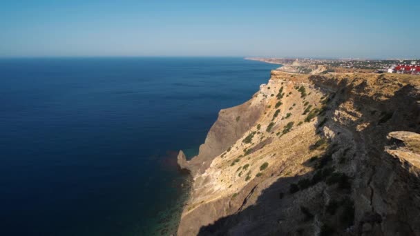 Vista aérea a la orilla del mar con altos acantilados de piedra caliza sobre el mar azul — Vídeos de Stock