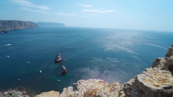Bucht und Yachten an der Küste mit hohen Kalksteinklippen über blauem Meer. — Stockvideo