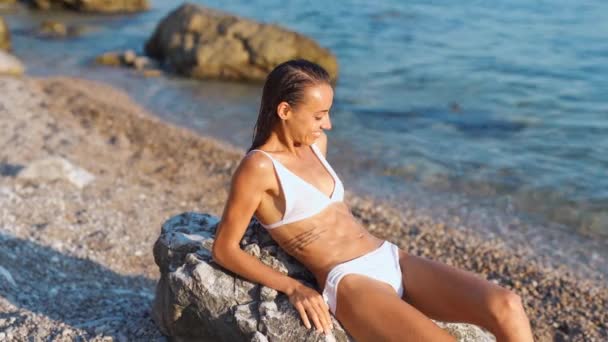Atractiva mujer sexy sonriendo y tomando el sol en la playa — Vídeo de stock