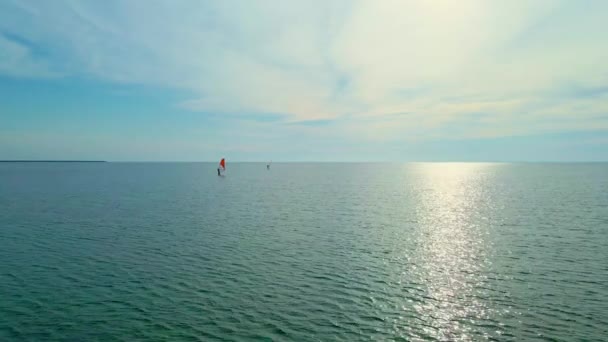 Uitzicht vanuit de lucht rustig zeeoppervlak en twee windsurfers — Stockvideo