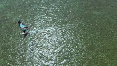 Dron görüntüsü yalnız sörfçü sakin deniz dalgaları üzerinde kayıyor