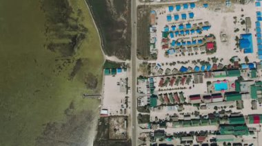 Koyu, yolu ve kulübeleri olan deniz kıyısı manzaralı havadan.