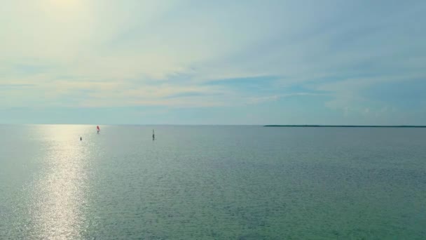 Вид с воздуха спокойная поверхность моря и два виндсерфера — стоковое видео