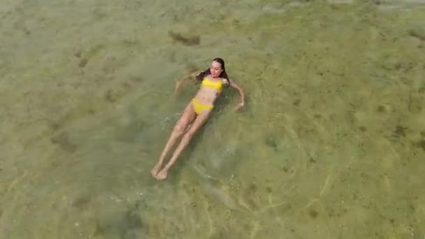 Vanuit de lucht uitzicht vrouw in bikini zwemmen in rustige zee — Stockvideo