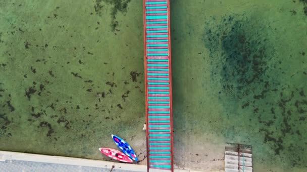 Surfovací stanice s kajaky a dlouhé dřevěné molo nebo most v moři — Stock video