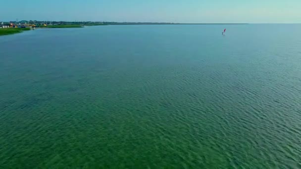Drone voando sobre o mar em direção ao windsurfista — Vídeo de Stock