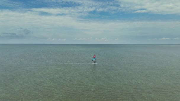Voo de drone sobre a superfície do mar calma com windsurfista brilhante — Vídeo de Stock