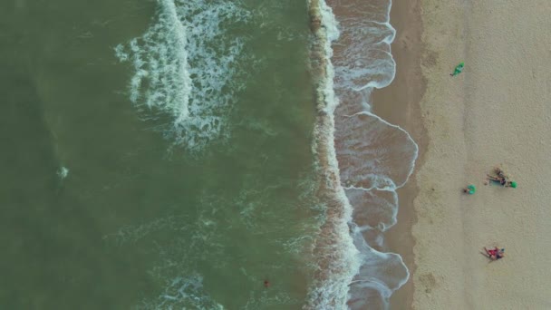Ondas batendo na praia de areia com pessoas na praia — Vídeo de Stock