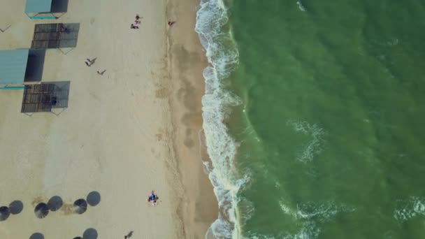 リゾートや太陽の傘やビーチのアトラクションと砂浜の海辺への空中の視点. — ストック動画