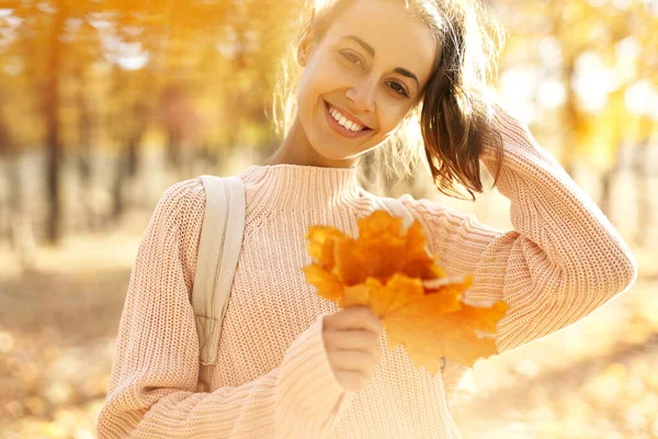 Closeup autumn sunlight portrait smiling woman holding maple leaves at sunny autumn park. — Stock Photo, Image