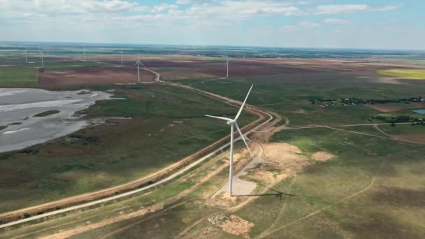 Vista aérea de la granja de aerogeneradores para la producción de energía en el fondo del campo — Vídeos de Stock