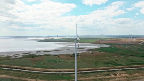 Drone bewegend rond windturbine met windgeneratoren park op achtergrond — Stockvideo