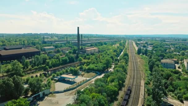 Σιδηροδρομική γραμμή προς το εργοστάσιο στη βιομηχανική περιοχή της πόλης κοντά σε κατοικημένη περιοχή με πράσινα δέντρα. — Αρχείο Βίντεο
