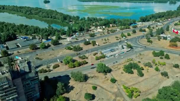 Luftaufnahme der Straße zwischen grünem Park mit Fluss und mehrstöckigen Gebäuden Bezirk in der Stadt. — Stockvideo