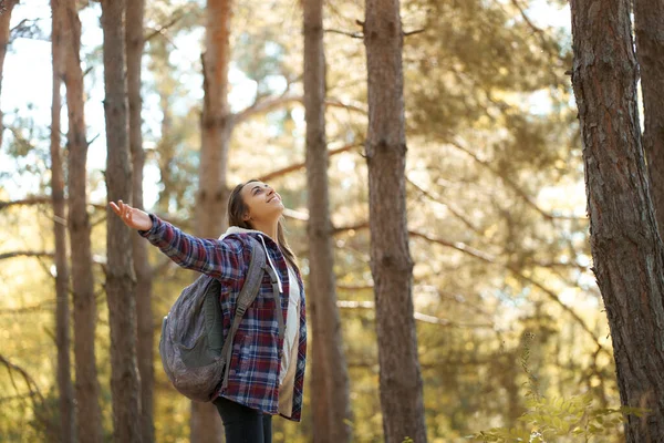 Excursionista turista mujer con mochila brazos abiertos en el bosque, disfrutando de otoño temporada de otoño. — Foto de Stock