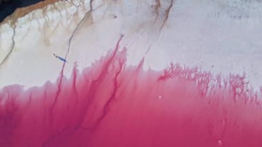 Pembe göl kıyısında, geniş, kuru, tuzlu sahil üzerinde insansız hava aracı uçuşu.