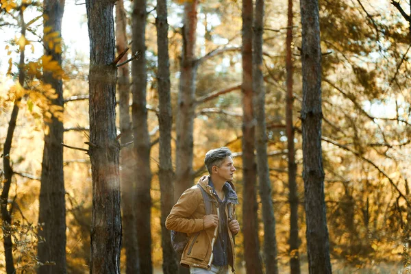 Hombre de estilo casual en bosques de otoño con mochila — Foto de Stock