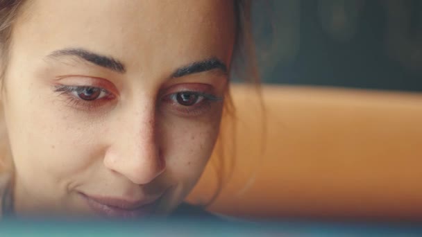 Extreme close-up jong mooi vrouw vreugdevol op zoek naar laptop scherm — Stockvideo