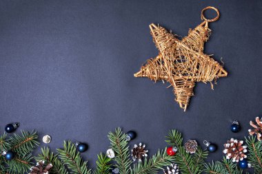 Noel Kavram Kartı. Altın Yıldız Ağaç Tepeciği. Arka plan Koyu Mavi. Noel süsleri. Süsler, koniler, dallar. Metnin için alanı kopyala. Üst görünüm