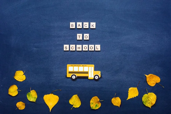 Wracając Koncepcji Szkoły Autobus Szkolny Litery Żółte Jesienne Liście Tle — Zdjęcie stockowe